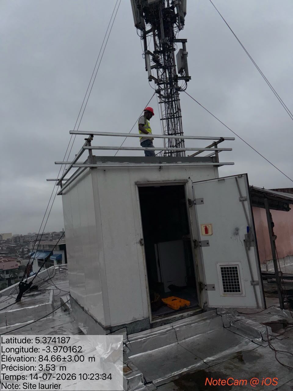 Technicien sur le toit d'un shelter télécom en réhabilitation
